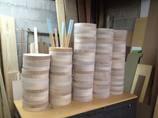A stack of circular tops lay in wait for their futures as colorful milking stools.