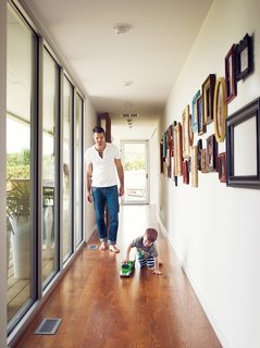 The hallway leading to the master bedroom is lined with an assortment of framed photos of family and friends and floor-to-ceiling windows overlooking the verdant James River Valley.