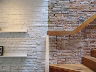 Revealing the Pros and Cons of Exposed Brick and How to Take Care of It - Photo 9 of 9 - Even when painted with an even coat of white paint, the texture of an exposed brick wall still comes through.