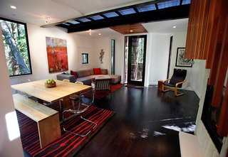 The metal grating floor on the second story allows light to filter through to the first level (living room shown). "You can sit or lay on the couch and see a 180-degree slice of the earth that you would just never see otherwise. It’s a different perspective of the world," says DeWitt.