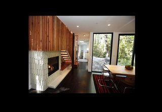 The interior metal grating motif is continued in these stairs made out of redwood from a tree on-site. A centrally located gas fireplace distributes heat evenly throughout the home as an energy-saving measure.