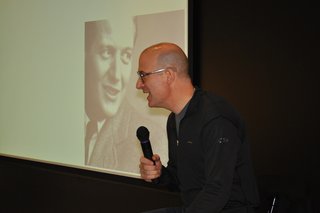 Pardo talks onstage with Knoll founder, Hans G. Knoll, projected on the screen behind him.
