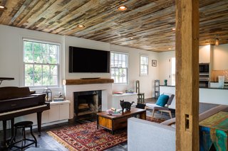 A few elements of the original home were preserved, such as the brick fireplace in the main living room, where an existing beam was repurposed to act as the mantel. The wood flooring is made of reclaimed fence boards, treated with a black finish originally employed to prevent horses from gnawing on the boards. "We all walk around barefoot, so it’s nice to feel the texture of the wood and all the history that was put into those boards. Over time, the dents and bruises will be put in there by our family, so it’s going to weather with us, which is nice," says Michael.