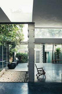 An Innovative Modular Building System in Ecuador - Photo 4 of 10 - Once past the main threshold, the house opens up to the outside, literally and figuratively. Three courtyards built around existing trees flow seamlessly into a series of rooms with glazed walls and sliding glass doors.