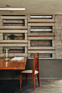 An Innovative Modular Building System in Ecuador - Photo 3 of 10 - "With this flowerpot form we saw an opportunity to do everything using only a single piece of concrete," says Sáez. "It’sa simple, direct form of architecture."<br><br>A cantilevered slab of Colorado wood, secured in the gap beneath a concrete block, serves as a dining table. Pasternak paired this with a vintage chair made of rare Caoba wood. To fill other gaps between blocks, the architects alternated strips of wood with strips of Plexiglas that let in light from the adjacent kitchen.