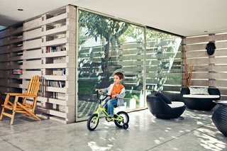 An Innovative Modular Building System in Ecuador - Photo 9 of 10 - Pentimento’s true versatility is revealed with each new tenant who inhabits the structure. As Nicolas demonstrates, the polished concrete floors make for an ideal biking surface. When playtime is over, he hangs his bike on the wall by the front door, suspending it from the handlebars to keep the floor tidy.