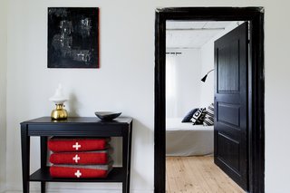 A black side table rests outside the bedroom hallway.