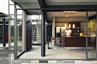 Alfredo chops away in the kitchen, which features floor-to-ceiling sliding glass walls.