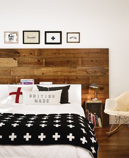 10 Cozy Spaces and 15 Products to Help You Get Ready For Fall - Photo 8 of 10 - Wide shiplap boards were reclaimed from the renovation of a 1920s bungalow in Austin, Texas. At the head of the bed, the wood acts as a focal point and brings a warmth to the space that's complemented by a rustic bedside table, a sheepskin throw on a chair, and an inviting bed layered with blankets and pillows.