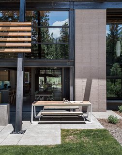 A Forest Sanctuary Designed to Support Autistic Triplets, Their Parents, and a Host of Caregivers - Photo 6 of 19 - A picnic table from Janus et Cie sits off the kitchen; the landscape architecture is by Richard D. Wood. In addition to passive solar, says Hawkins, "there is the added benefit of a thick concrete slab as a thermal mass that absorbs and stores the heat from the sun."