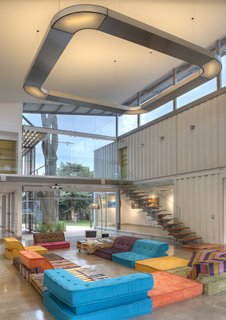 Who Knew a Relaxing Tropical Retreat Could Be Made of Shipping Containers? - Photo 7 of 10 - Trejos positioned the containers about 60 centimeters above the ground floor, which gives the main gallery and workspace a bit of a sunken feel. The double-level main room offers a spacious interior, perfect for large events and easily altered so it can be utilized as a photo studio for indoor shoots.