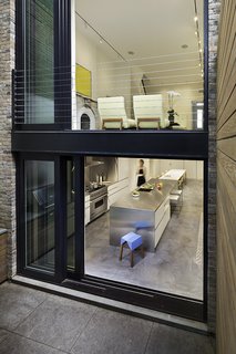 The rear of the house is virtually all glass, essential for ensuring the 15-foot-wide structure doesn't feel claustrophobic. "Our office obsesses over the color and quality of light, both through physiological understanding as well as keeping up with the latest technological trends," Lubrano says. "In this project, color is presented through the natural characteristics of materials. The garden level floor is a smooth but visually textured concrete. The upper floors are white-washed wood, allowing the grain to present itself. The walls were plastered to a perfect finish and the trim was painted in selected hues of white. The tactile nature of surfaces is very important."