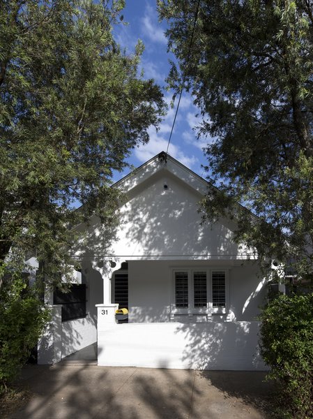 The façade of the interwar dwelling was painted bright white and left largely unchanged, with a sole burst of color coming from a yellow DesignByThem “tomtom” letterbox. Though the extension is invisible from the street, architect Christopher Polly says it provides “significant additional freedom for the owners and their three young children to grow into.” Photo 2 of Cosgriff House modern home