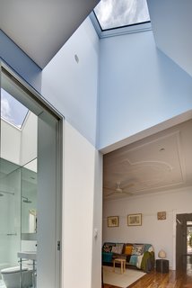 Renovation Near Sydney Opens Home Onto a Lush Garden - Photo 8 of 8 - Save for a new fan and a coat of oil on its pine floors, the original living room remains unchanged. The master bathroom, however, has been completely refurbished with Scala accessories and a Duravit Happy D wall basin. Both rooms are brightened by skylights carved into the roof.