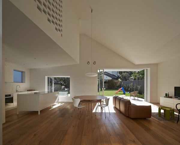 “The walls are painted brick to reinforce the connection to the exterior of the house,” Trimble says of the combined dining and living area. Clad in European oak flooring, the warm space features Series 7 chairs by Fritz Hansen, a Soverin Table by Andreu World, and a comfy, leather Marenco sofa by Arflex. Photo 4 of Riverview modern home