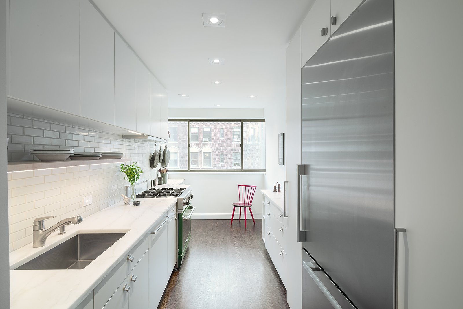 The homeowners, avid cooks, worked with a design duo and a contractor found on the site. To make the kitchen seem larger than it is, the team decided to place the largest cabinets and appliances near the entryway, with less clutter toward the window.