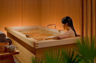 Japanese Soaking Tubs - Photo 10 of 13 - Zen BathWorks strengthened this large tub with an apron that doubles as a cup rest. The room’s walls are wood-clad to reduce visual clutter and the tub rim is indented to direct water towards a floor drain shared by a shower. Soaking tubs are often smaller than conventional tubs as the bather sits with knees to chest-great if you have a small bathroom but want a tub. Sides can be sloped or straight and wood with knots generally costs less than straight-grained planks. If you’re curious about cedar’s scent, the bars sold in hardware stores for use as a moth-repellent give a general idea. Photo courtesy of: Zen BathWorks
