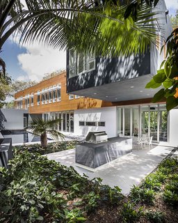 An elegant pool and outdoor kitchen extend from the living areas.