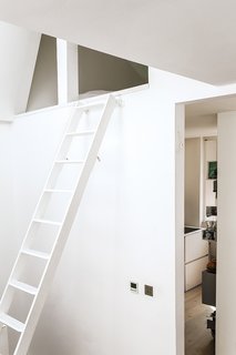 An alcove above the kitchen discreetly houses a sleeping space for guests.