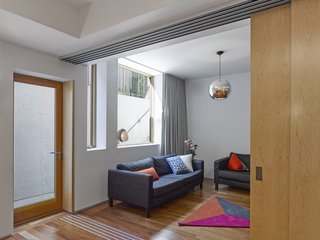 Active systems, in addition to thoughtful orientation and structural planning, help the structure become ultra efficient. The primary heating source throughout the house is radiant flooring connected to a geothermal system. Tedesco specified the Uponor Climate Control Network to operate the systems. "Every heating zone can be scheduled for setback," he says. "Then, through the communication and coordination of zone operation from main control panel that monitors the entire system, equipment and zones are cycled in harmony. The entire climate control system including the geothermal, ERV, A/C, and heat pumps is balanced to maintain optimal performance and occupant comfort. The Lutron Maestro lighting control, home entertainment, and security system can all be monitored and controlled remotely through a web-based program provided by the equipment supplier. The entire system has wireless access points throughout the house to ensure conductivity." The media room sofas are Ikea's Karlstad model, the rug is by Bev Hisey Textile Design, and the pendant is the Caprice by Viso.