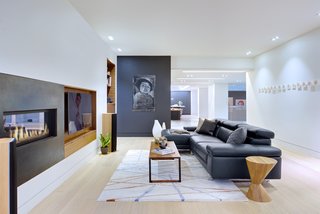 "Inside," says designer Daniel Harland, "we wanted to keep the material palette fairly minimal, especially since many spaces look onto each other." Most of the millwork is a combination of quarter-cut American black walnut and acid-finished cold-rolled steel. The artwork is by Dana Prieto, the coffee table and side table are by Hollis+Morris, and the area rug is by Kelly Wearstler.