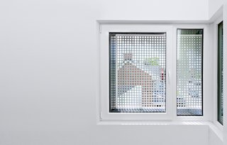 Inside, perforated window screens reference the light fixture in the courtyard, "offering an abstract, fragmented glimpse of the tulips inside," explains Harland.