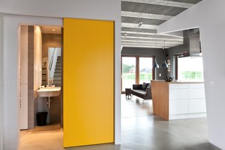 25 Bold Ways to Decorate with Yellow - Photo 25 of 25 - Canary yellow doors keep the house from feeling austere. The sliding function also saves space.