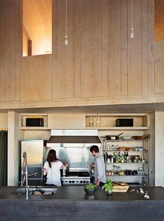The kitchen island is topped with PaperStone in slate and wrapped in the same steel used to clad the house’s facade. "We matched the color to create a ‘2001: Space Odyssey’ monolith," Garlick says. He and his wife, Susan Elliott, a chef, cook at the commercial Wolf range they purchased at a restaurant supply store.