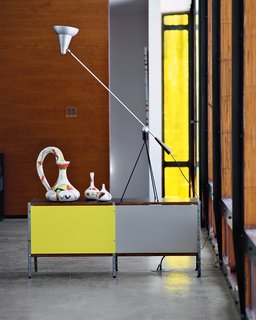 "Materials were a major consideration in this house," says Massie, who created a curtain wall with steel supports adorned with sandwiched layers of birch plywood and amber acrylic. "When light enters that wall, the layers of acrylic allow it to come through and glow—it’s really quite beautiful," says Massie, who added the same acrylic for the thin window at the end. "That plays off the yellows in the Gambone ceramics and the Eames storage unit," notes Wooten.