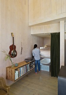 The floating bookshelf is composed from wood found on the property. Garlick purchased the Technics turntable and receiver from a used audio store.