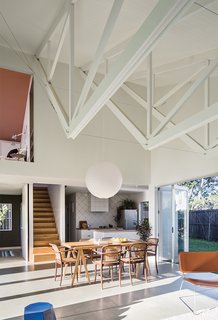 In a newly built New Zealand bungalow, the kitchen is tucked under a bedroom adjacent to a soaring double-height great room.