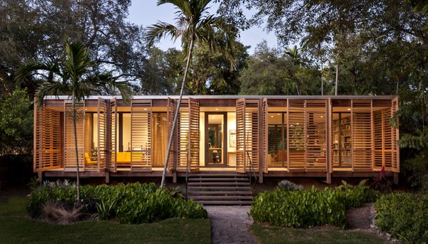 The 1,500-square-foot home features a striking interplay of sharp glass and soft wood shutters, creating a simple and practical building that’s rich in cultural heritage. The home takes inspiration from many native building styles, including postwar tropical modernism, glass pavilion typology, and Florida cracker architecture. The dense ipe wood that clads the exterior and columns was chosen to withstand potential termite attacks and the damp tropical climate. Photo of Brillhart House modern home