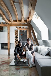 Herrman, his wife, Cécile, and their young daughter, Rose, play on the Pont table by Ligne Roset . The Carmo sofa is by Anders Nørgaard for BoConcept.