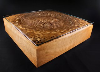 EndGrain’s Ripple Coffee Table, shown here in cherry hardwood and glass, is a graphic representation of a the surface movement created by a ripple of water. Made up of cut squares of wood individually assembled back together, it is a good representation of the tension between natural and structure that often exists in Rupich’s work.