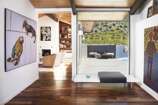 Inside, a Herman Miller bench creates a small sitting area. A rich collection of artwork, amassed over the years by the Saleks' mother, Mahshad, is visible at every turn. The flooring throughout is a warm walnut.