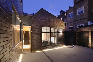 10 Dwell-Approved, New-Old Homes in the UK - Photo 1 of 18 - The renovated industrial compound is clad in metallic bronze-glazed bricks from Modular Clay Product, which match the neighboring Victorian terrace homes. The reflective bricks change in appearance as the sun moves through the sky, but always echo the Bronze Casements by Vale windows.