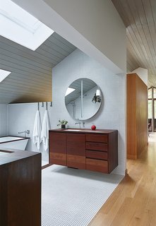 A vaulted ceiling, mosaic tile, and a custom tub with an ipe-slat basin make a third-floor master bathroom in Kansas City, Missouri, feel like a true getaway.