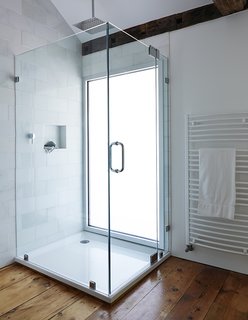 10 Best Modern Showers to Inspire Your Bathroom Renovation - Photo 6 of 10 - A glass-lined shower with a Hudson Reed shower head adds a modern touch to the second-floor bathroom in this farmhouse renovation. A pane of privacy glass lets natural light enter the room, illuminating the shower stall.