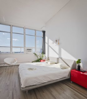 Brooklyn Loft Renovation Masters Storage With a Custom Cabinet Wall - Photo 10 of 10 - Last but not least, the western-facing master bedroom captures stunning sunsets from its wall-to-wall windows.
