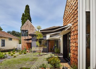 This Transformed Melbourne House Resembles a Quirky Village - Photo 7 of 11 - "It was very important to get the integration between the garden and the house right," Maynard says. The architects worked with Bush Projects to strike that balance, laying down concrete pavers and planting native flora that add to the home’s relaxed feel. Permanent steel awnings protect windows from glare, while retractable fabric ones by Shadefactor offer residents optional shelter when they sit outside.