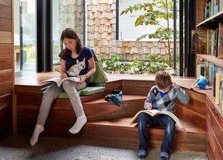 This Transformed Melbourne House Resembles a Quirky Village - Photo 10 of 11 - Responding to restrictions set by local planning authorities, the architects lowered the library’s floor level to preserve its cathedral ceilings. "We try to work with problems, not against them," Maynard says. "You now descend three steps into the studio and discover the desk at garden height, rather than above it." The solution also allowed for the installation of built-in reading nooks.