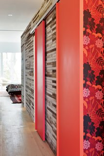 Maira wallpaper from the 70s adorns the guest bathroom. When they knocked down several interior walls, Sawatzky and Flanders were left with tons of lath—the thin, irregular strips of softwood that provided the base for wall plaster. With the help of a demolition contractor, they sorted out the cleanest pieces to reuse. The couple clad the box on the second floor that contains their bathroom and closets with the lath, nail-gunning each piece to the walls.