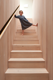 This Kid-Friendly Home is Full of Surprises - Photo 4 of 9 - Cooke treated the southern beech in the stairwell with natural oils, rather than polyurethane, to bring out the grain and warmth of the natural materials. To keep the surface visually clean and minimal, the balustrade is set into the wall, so wood wraps the stairwell from ground floor to skylight.