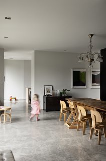 This Kid-Friendly Home is Full of Surprises - Photo 7 of 9 - The 1920s Catalan chandelier and dining room table were both bought second-hand from a shop in Barcelona, where the family used to live. The table is the perfect place for the children to draw and play, "because it’s so old it doesn’t matter if it gets scratched," says Bergendy. "It’s technically a dining room with old-style wood panels, but the treatment is new — it’s not cutting edge, but the way the materials have been treated is different."