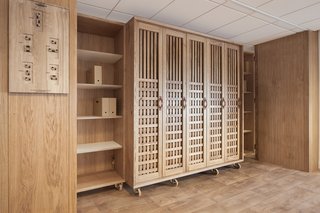 A Modular Meeting Room Features a Table with 6 Possible Layouts - Photo 5 of 6 - A wooden wardrobe provides storage, while a carved and burnt-wood board provides visual instructions explaining the room's possible configurations