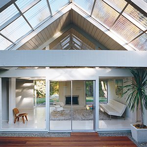 A Leg Splint Inspired Charles and Ray Eames' Famous Molded Plywood Lounge Chair - Photo 7 of 8 - The literal and figurative centerpiece of this Portland home is the atrium. An LCW adds a natural touch to an otherwise white space.