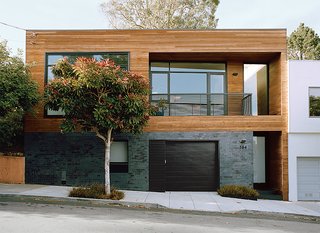 The contemporary renovation of this 1930s fixer upper resulted in a 1,800-square-foot residence that feels expansive, thanks to an ingenious use of natural materials and space-saving design. For the facade, architect Cary Bernstein used Ironspot clay tiles and FSC-certified cedar. The entryway was also reconfigured for the street level. Guests then ascend straight to the main living space. 