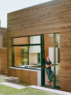 To reinforce a streamlined aesthetic, materials move from the inside out and from room to room. A Caesarstone countertop in the kitchen extends through a window to the backyard. The basalt path in the house continues outside and up the outdoor stairs.