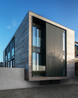 10 Gravity-Defying Cantilevered Homes - Photo 23 of 23 - The house cantilevers slightly over a concrete wall, adding a touch of lightness and drama to its approach. Stairs beside to the cantilever lead to the entrance. On the upper level, a bedroom and family bathroom look out through the windows of the cantilevered façade.