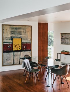 A Midcentury Home Enjoys Views from Every Angle - Photo 13 of 14 - In the dining room, artworks by Alan Davie (at left) and Martin Bradley join a Norman Foster dining table.